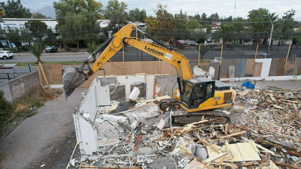 Excavadora demoliendo una vivienda de un piso en Santiago